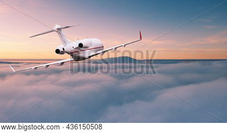 Private jetplane flying above dramatic clouds