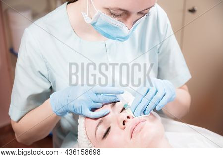 Cosmetology. Close-up Of The Beautician S Hand And The Patient S Face Before An Injection Of Hylauro