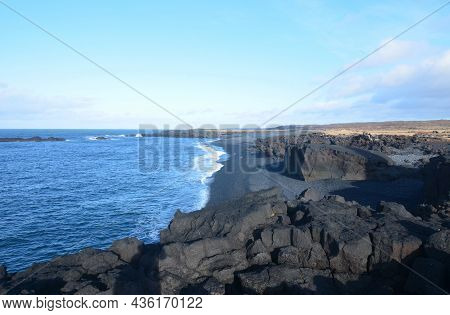 Waves On A Black Lava Rock Beach In Iceland.