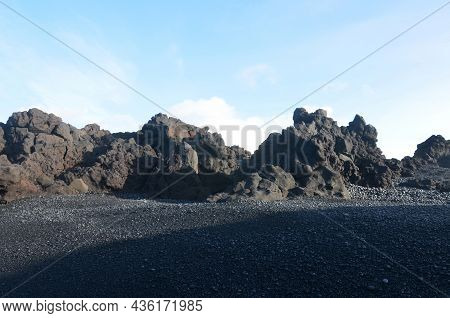 Large Black Lava Rock Formation On Dritvik Beach In Iceland.