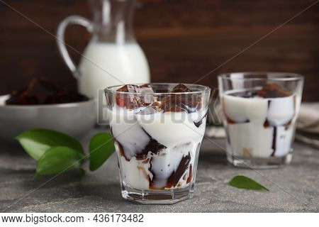 Glasses Of Milk With Delicious Grass Jelly On Grey Table