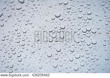 Raindrops On Glass Against Gray Sky Closeup