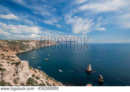 Two Rocks Stick Out Of The Water In The Middle Of The Turquoise Sea. Scenic Ocean View. Speed Boat S