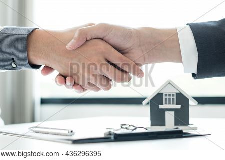 Businessmen And Brokers' Real Estate Agents Shake Hands After Completing Negotiations To Buy Houses 