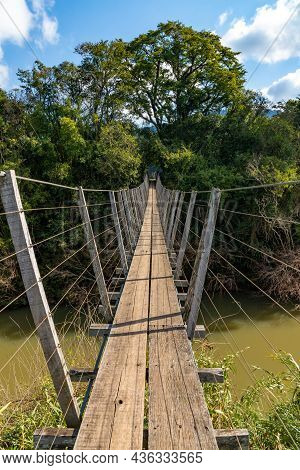 Wood And Iron Bridge Over Cadeia River With Forest Around