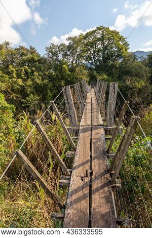 Wood And Iron Bridge Over Cadeia River With Forest Around