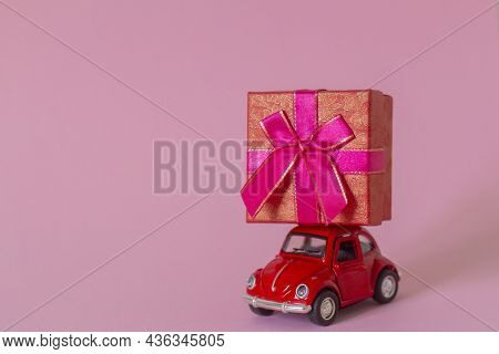 01.10.2021-zavyalovo, Russia.a Small Metal Red Retro Car With A Gift Box.the Concept Of Gift Deliver