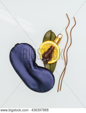Spa Relax Composition With Sleep Mask, Orange Slace And Orange Oil In A Jar On A Blue Background. Or
