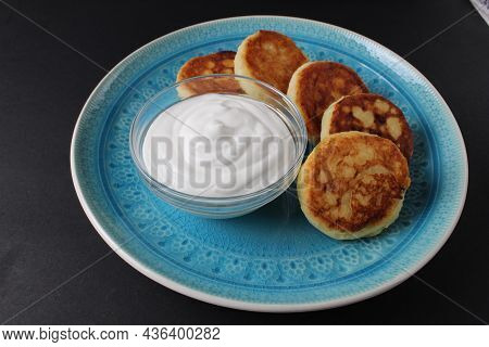 Breakfast Cheesecakes Curd Pancakes A Few Five Pieces Lie On A Large Blue Dish Plate With White Sauc