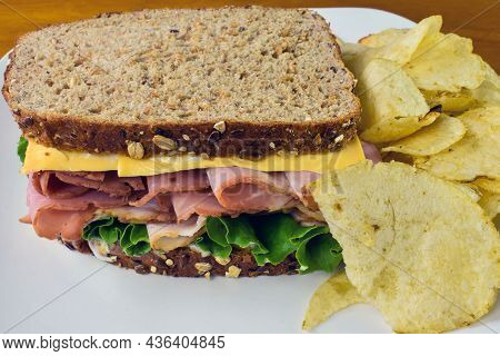 Ham Sandwich With American Cheese With A Side Of Potato Chips,.