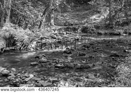 Long Exposure Of The Horner Water River Flowing Through Horner Woods In Somerset