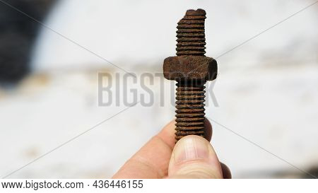 Old Rusty Bolt, Iron Rod With Screw Threads, In Hand. Rusted Mechanical Components. Holding Threaded
