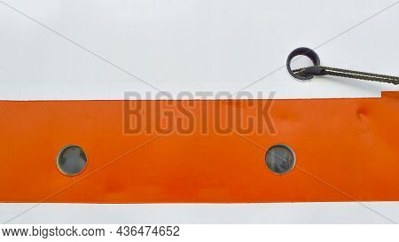 Two Small Portholes On The White-orange Side Of The Ship Close-up