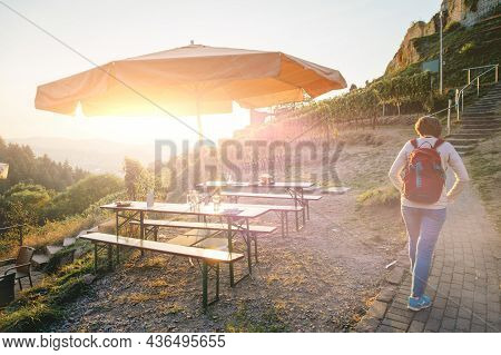 Rear View Of Woman Walking At Sunset Toward Schauenburg Castle In Oberkirch, Baden-wurttemberg Germa