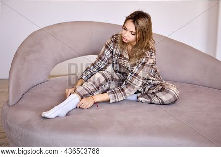 Legant Woman In Pajamas Sits On Bed At Home.