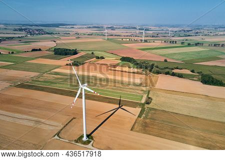 Windmill Among Agricultural Fields. Wind Turbine Generator At Summer Day. Wind Energy Concept. Suist