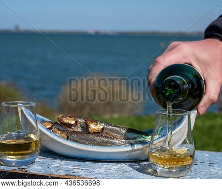 Smoked Sprattus Or Sprats Sea Fish Served Outdoor With View On Blue Sea Water