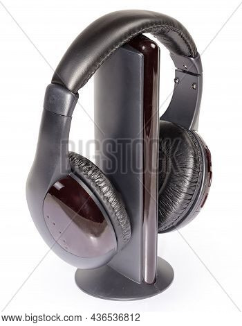 Black Modern Wireless Full Size Closed-back Headphones Hanging On Its Emitter On A White Background
