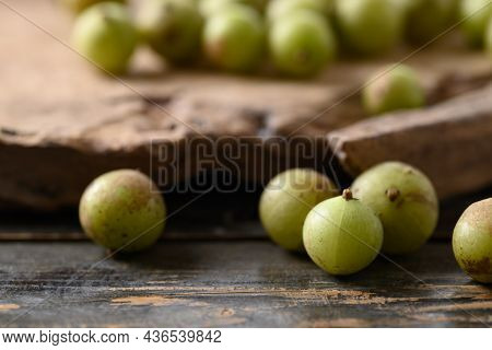 Wild Indian Gooseberry Or Amla On Wooden Background, Fruit Tree In Asia Use In Various Cuisine, Herb