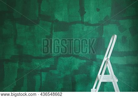 White Step Ladder In Front Of Green Painted Wall. Home Repair Concept, Landscape Shot.