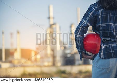 Woman Emergency Workers Hands Holding Hardhat Red Work Helmet Engineer. Refinery Plant Woman Worker 