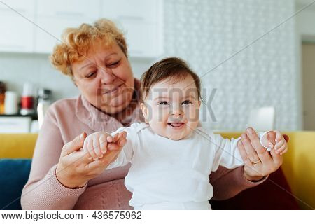 Happy Caucasian Grandmother Playing And Holding Her Little Granddaughter At Home. Affectionate 2 Two