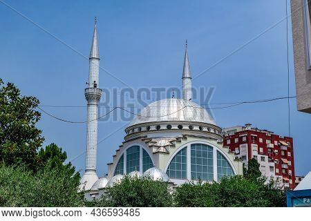 Shkoder, Albania - June 21, 2021: Silver Dome And Two Minarets Of The Ebu Beker Mosque Against The B