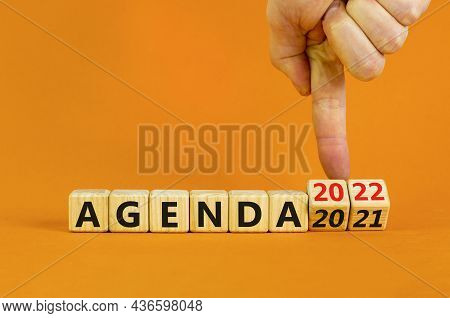 Planning 2022 Agenda New Year Symbol. Businessman Turns Wooden Cubes And Changes Words 'agenda 2021'