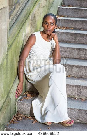 Dressing In A Long White Dress, Sitting On Steps, One Arm Supporting Her Head,  A Young Pretty Black