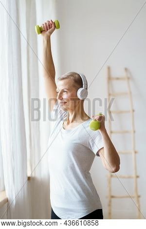 Vertical Portrait Smiling Senior Woman Exercising Fitness With Dumbbells At Home. Mature Female Buil
