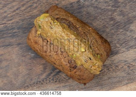 Overhead View Of Freshly Baked Loaf Of Banana Bread Slathered With Pistachio Butter And Served On A 