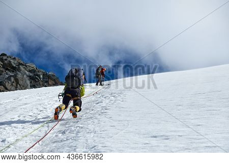 Bunch Of Mountaineers Climbs Or Alpinists To The Top Of A Snow-capped Mountain