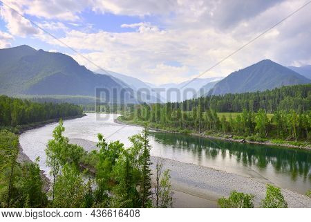 The Bend Of The Riverbed Against The Background Of Mountains Under A Blue Cloudy Sky In Summer. Sibe