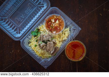Roasted Meat Served With Rice And Chillies Tamarind Sauce And Curry Gravy In A Take Out Container. M