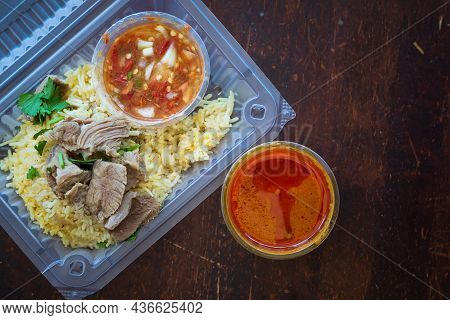 Roasted Meat Served With Rice And Chillies Tamarind Sauce And Curry Gravy In A Take Out Container. M
