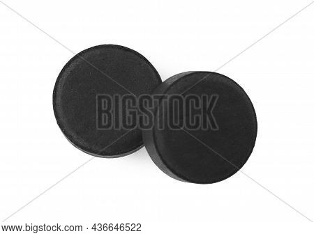 Activated Charcoal Pills On White Background, Top View. Potent Sorbent
