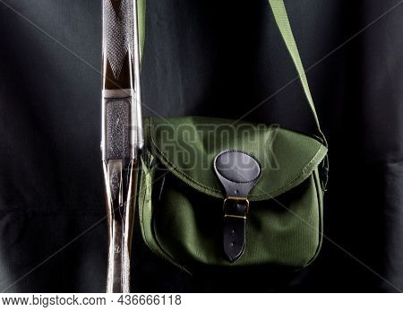 Cartridge Bag And Shotgun Upright On An Old Waxed Cotton Coat