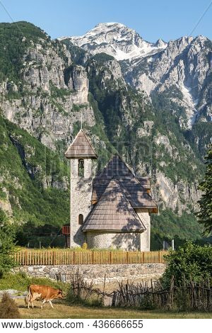 Christian Church in the village of Theth with Prokletije or Acursed Mountains at background in Theth National Park, Albania.