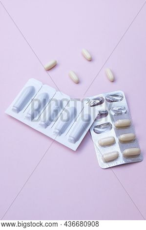 Gynecological Medicines For Women's Health In Form Of Suppository, Capsules On Pink Background.