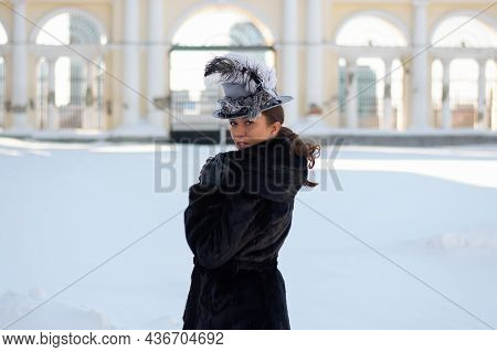 A Woman Dressed As A 19Th Century Noblewoman Stands Near An Old Manor House.russian Winter