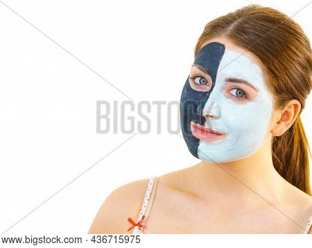Woman With Clay Carbo Black Mask On Half Face And White Mud On Second Half. Girl Taking Care Of Oily