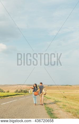 Young Guy And Girl Are Hitchhiking. Thumb Up. Concept - Adventure, Free, Freedom. Copy Space