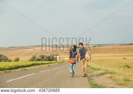 Young Guy And Girl Are Hitchhiking. Thumb Up. Concept - Adventure, Free, Freedom. Copy Space
