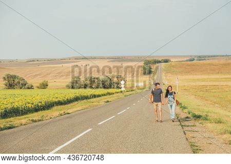 Hitchhiking. Thumb Up. Young Brunette Girl In A Denim Jumpsuit Is Hitchhiking Around Country. Free S