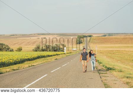 Hitchhiking. Thumb Up. Young Brunette Girl In A Denim Jumpsuit Is Hitchhiking Around Country. Free S