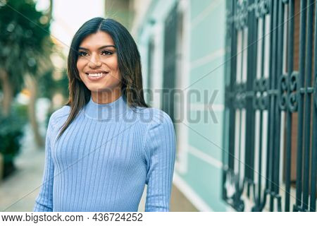 Beautiful hispanic woman smiling confient at the city