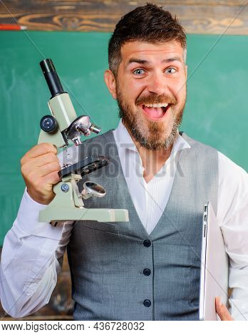 Biology Or Chemistry Concept. Happy Teacher With Computer And Microscope. Excited Tutor In Classroom