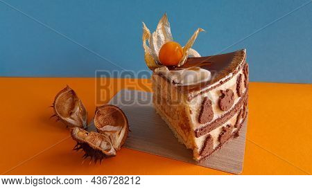 Piece Of Fruit Cake, Chestnut Peel On An Orange-blue Background. Sweet Composition