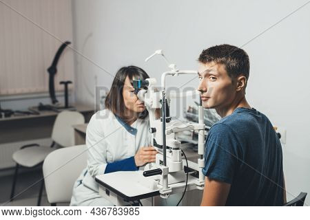 Doctor Optometrist Examines Sight Of Guy. Concept Of Visual Impairment In Adolescents. Vision Tests