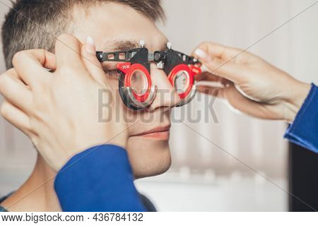 Doctor Picks Up Glasses To Correct Farsightedness Teenager. Concept Of Visual Impairment In Adolesce
